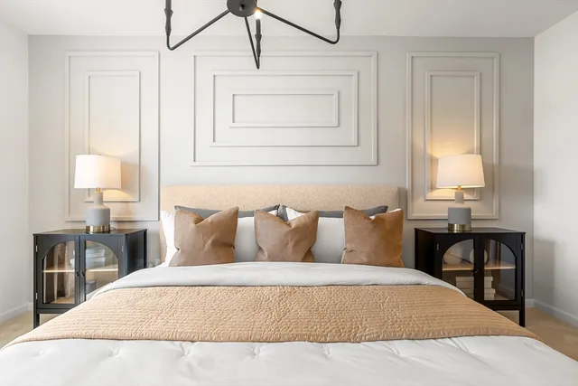 a bedroom with a bed a table and painting on the wall