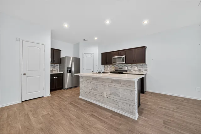a large kitchen with a stove a sink and a refrigerator
