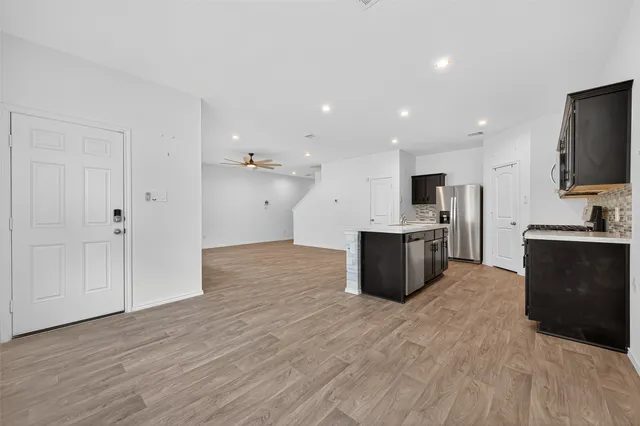 a large kitchen with stainless steel appliances kitchen island granite countertop a large counter top and wooden floor