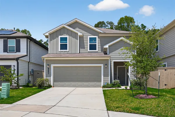 a front view of a house with a garden and trees