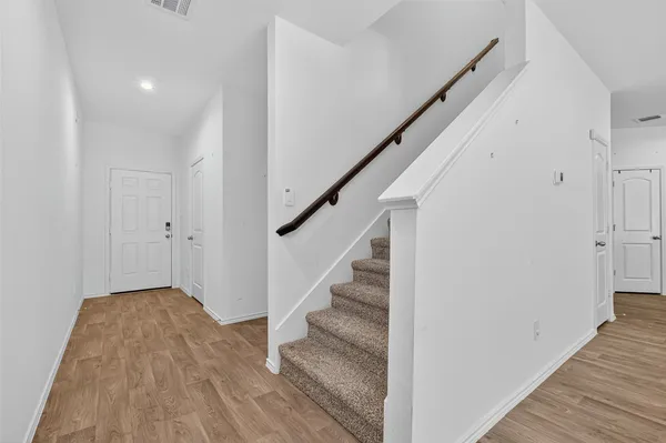 a view of entryway and hall with wooden floor