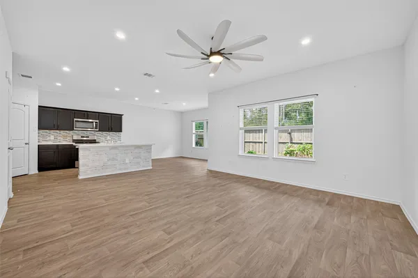 a view of a livingroom with a ceiling fan and wooden floor