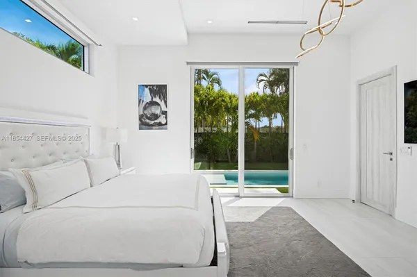 a view of swimming pool with lawn chairs and large trees