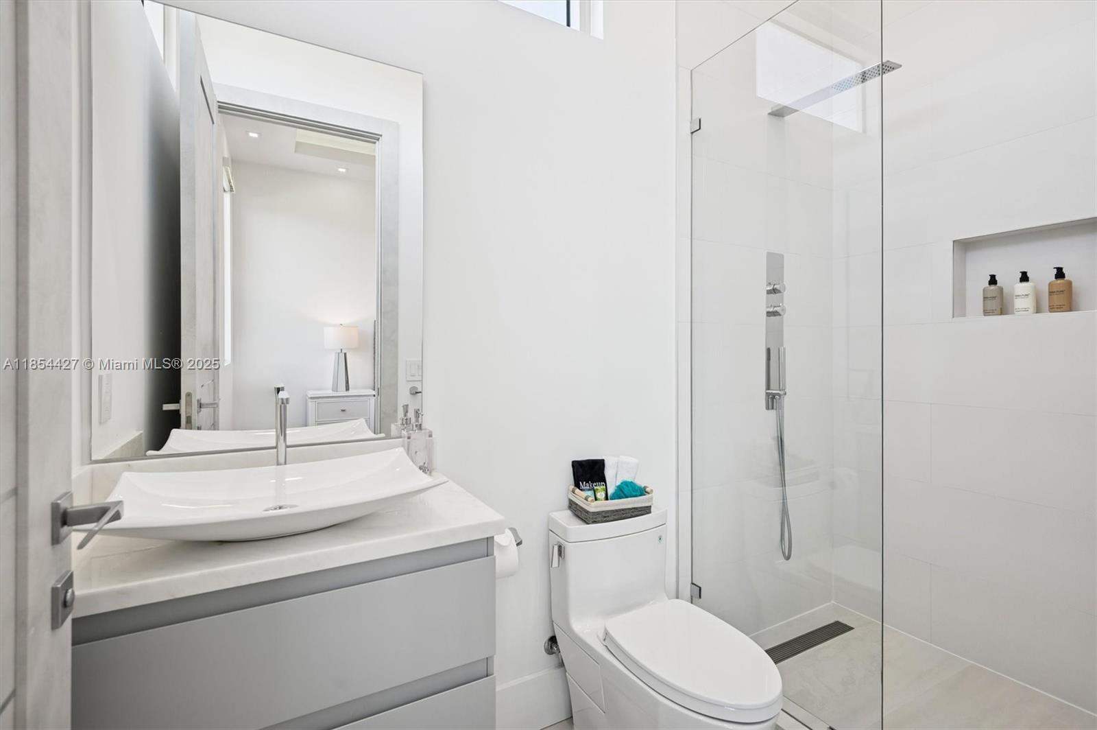 2628 Marcinski Road Jupiter, FL 33477 - Photo 46 of 70 a bathroom with a toilet sink vanity and mirror