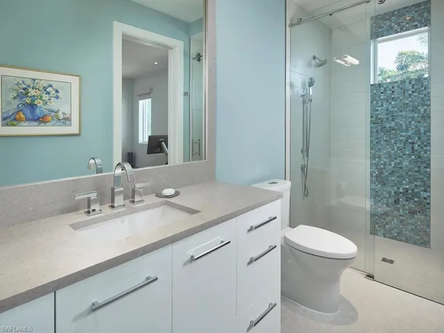 a bathroom with a sink a toilet and shower