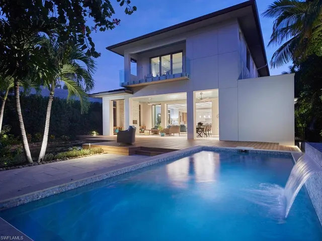 a view of a house with pool and sitting area