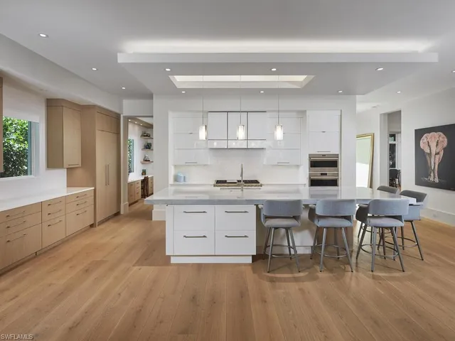 a large white kitchen with lots of counter space and a sink