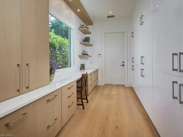 a kitchen with cabinets and wooden floor