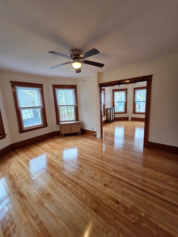 a view of a livingroom with wooden floor and a ceiling fan