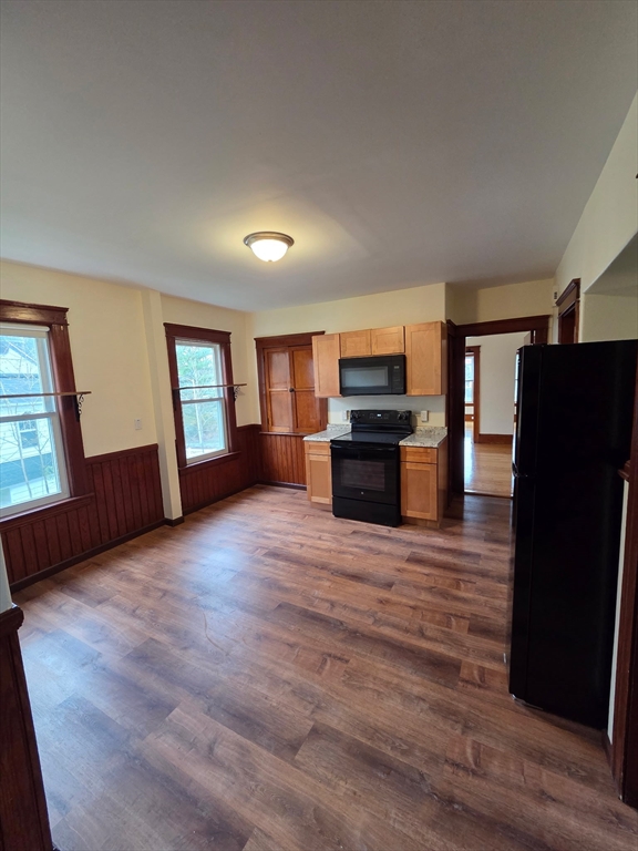15 Berkmans Street, Unit 2 Worcester, MA 01602 - Photo 6 of 13 a view of kitchen and empty room with wooden floor and window
