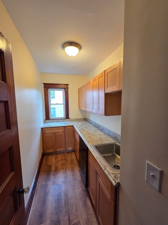 15 Berkmans Street, Unit 2 Worcester, MA 01602 - Photo 8 of 13 a kitchen with granite countertop a sink and wooden floor