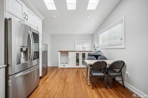 a view of a kitchen with dining table and stainless steel appliances