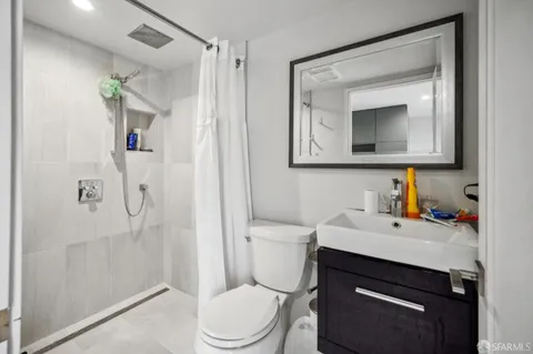 a bathroom with a sink a toilet and shower