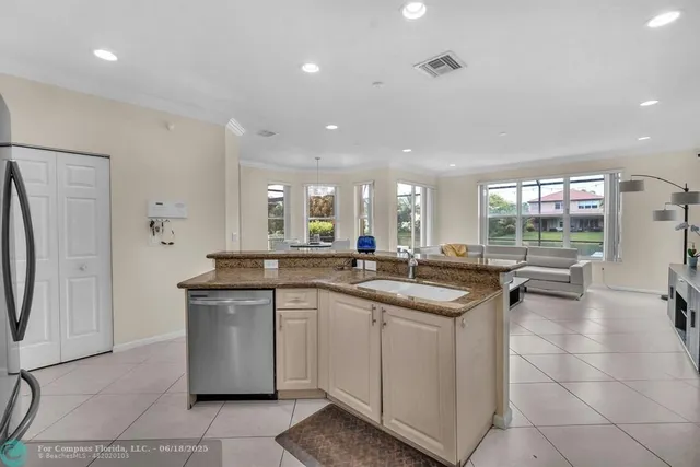 a kitchen with stainless steel appliances granite countertop a sink refrigerator and cabinets
