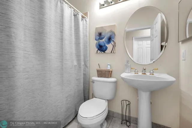 a bathroom with a double vanity sink mirror and toilet