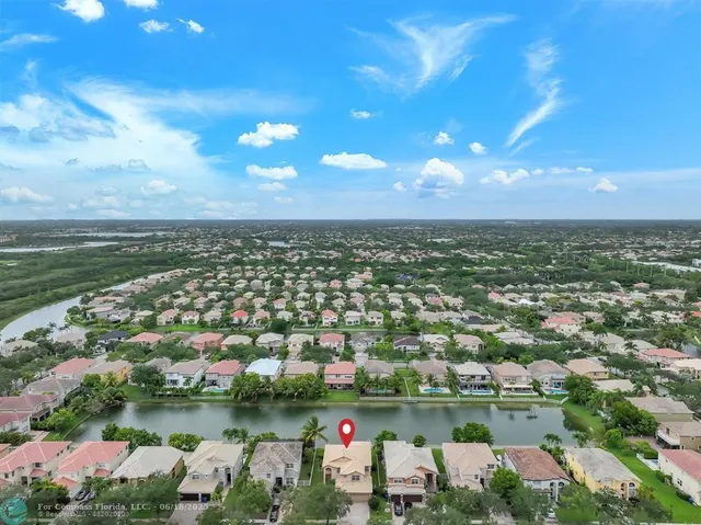 an aerial view of residential houses with outdoor space and lake view