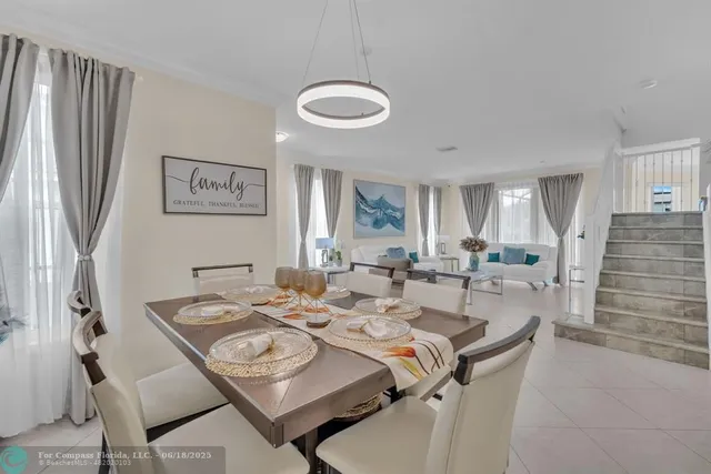 a view of a dining room and livingroom with furniture wooden floor and a chandelier