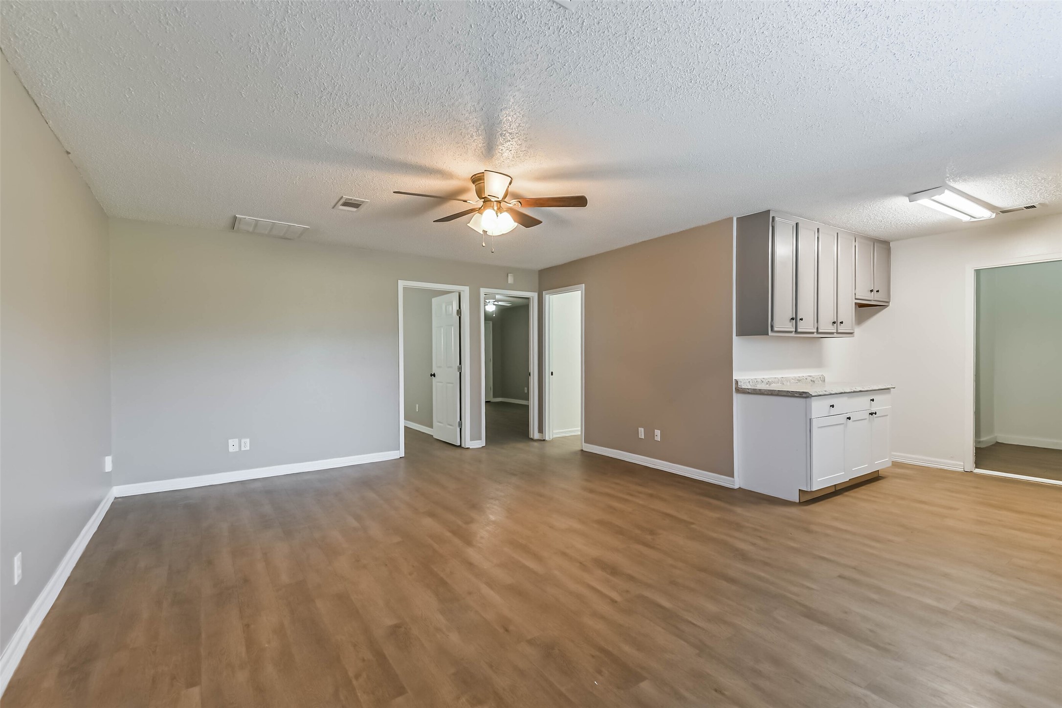 4869 Fm 2518 Cleveland, TX 77327 - Photo 14 of 41 a view of a kitchen with wooden floor and a ceiling fan