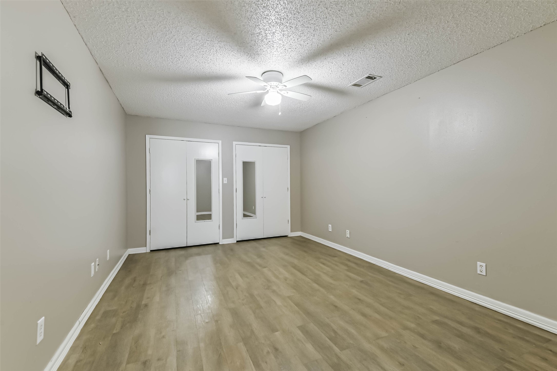 4869 Fm 2518 Cleveland, TX 77327 - Photo 22 of 41 a view of an empty room with wooden floor and a ceiling fan