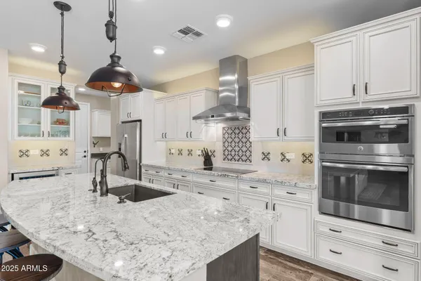 a large kitchen with kitchen island lots of counter space and a sink