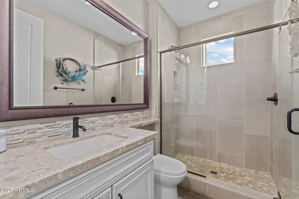 a bathroom with a sink toilet a mirror and shower