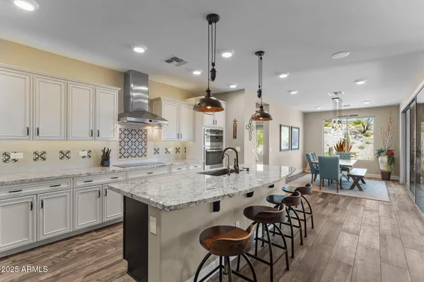 a kitchen with stainless steel appliances granite countertop a sink and a stove