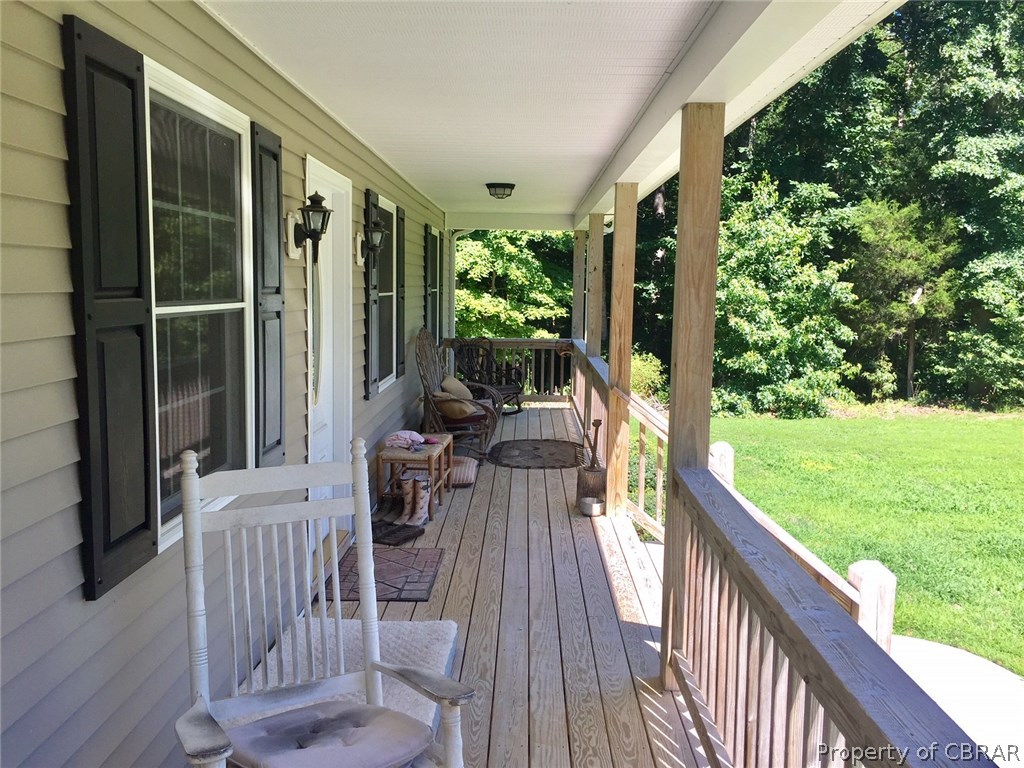 View of front porch overlooking lush lawn and trees.