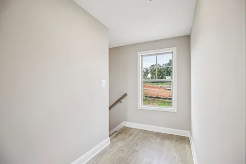 a view of a room with wooden floor next to a yard