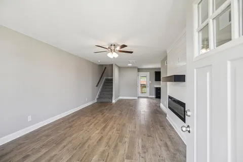 a view of a livingroom with wooden floor and a ceiling fan