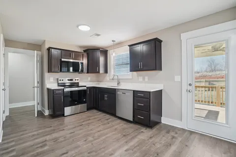a view of a kitchen with a refrigerator and wooden floor