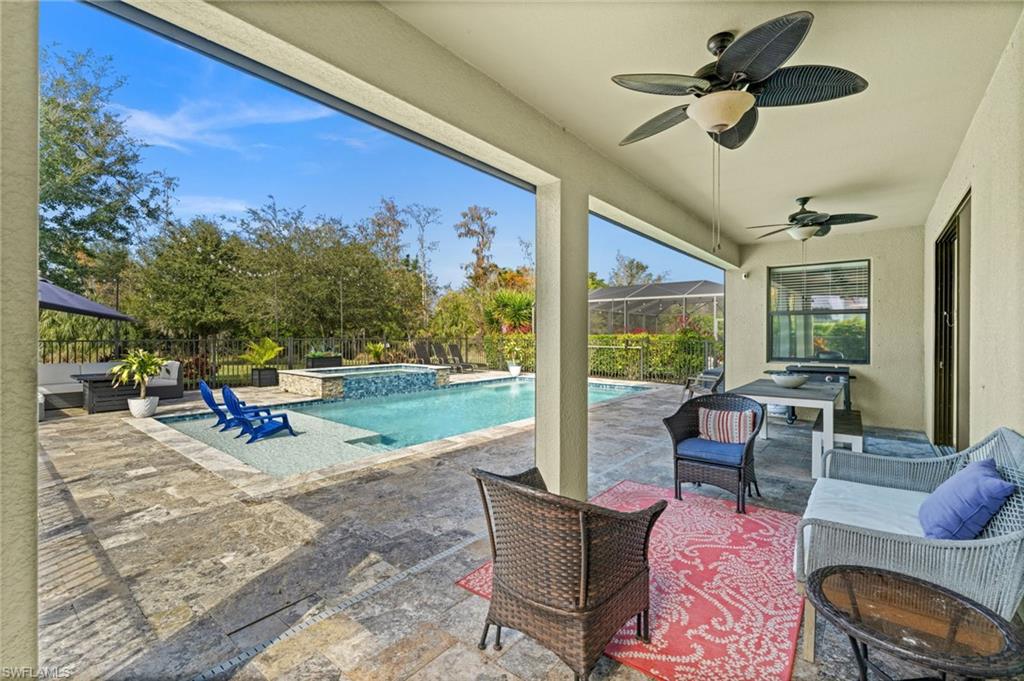 4754 Abaca Circle Naples, FL 34119 - Photo 34 of 46 a living room with patio furniture and a floor to ceiling window