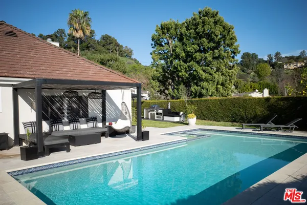 a view of a house with backyard and sitting area