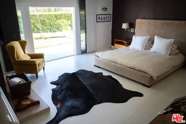 a bedroom with a bed window and a chair