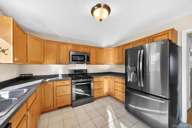 a kitchen with stainless steel appliances granite countertop a refrigerator sink and stove