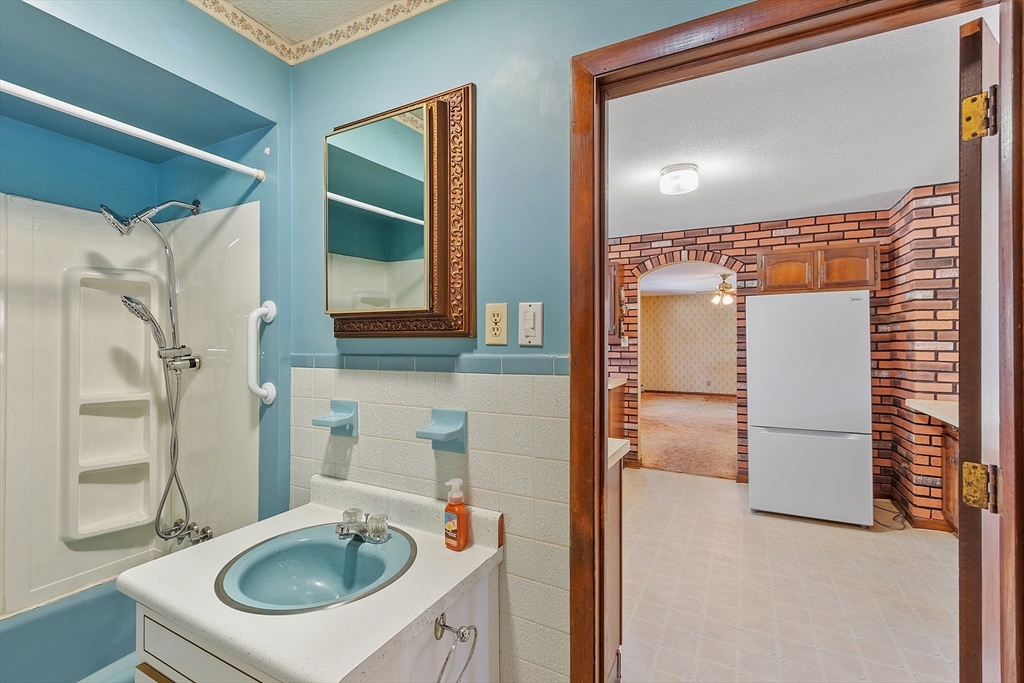 318 Lovewell Street Gardner, MA 01440 - Photo 19 of 42 a bathroom with a sink a mirror and a shower
