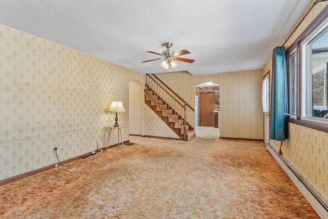 an empty room with windows and fan