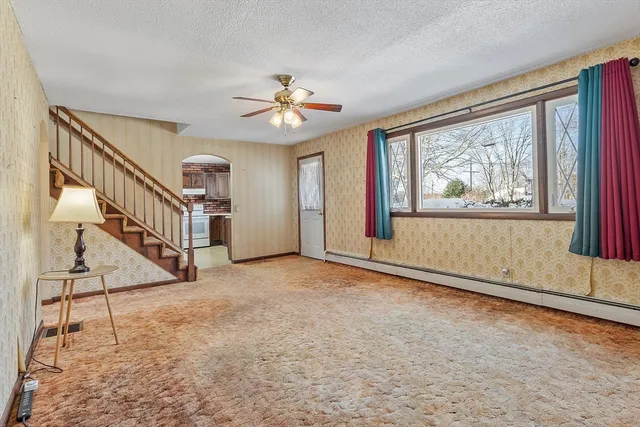 a view of a hallway with wooden floor and a bathroom
