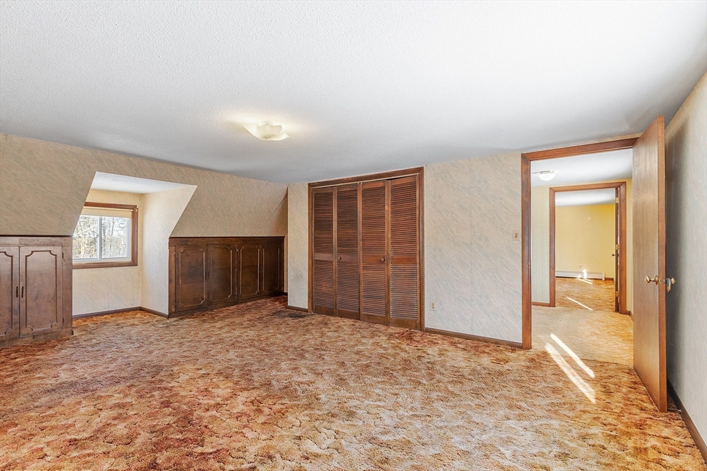 318 Lovewell Street Gardner, MA 01440 - Photo 31 of 42 an empty room with windows and cabinet