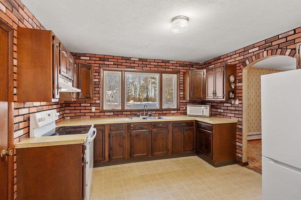 318 Lovewell Street Gardner, MA 01440 - Photo 10 of 42 a kitchen with stainless steel appliances granite countertop a sink and cabinets