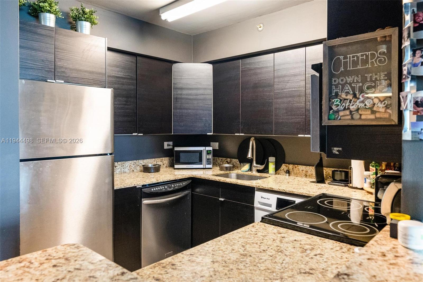 1500 Bay Road, Unit 458S Miami Beach, FL 33139 - Photo 7 of 41 a kitchen with a sink refrigerator and cabinets