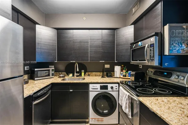 a kitchen with stainless steel appliances granite countertop a sink stove and refrigerator
