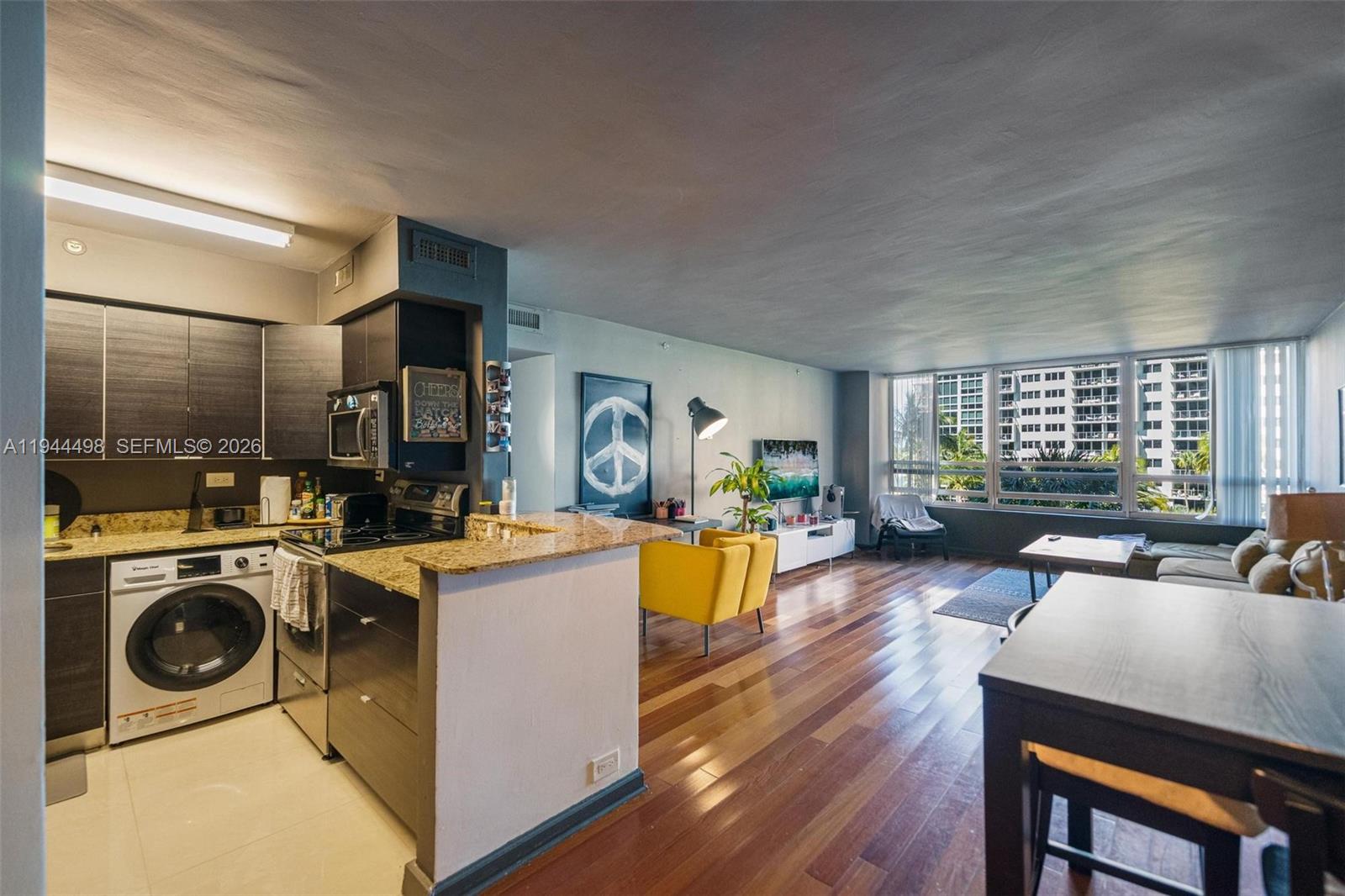 1500 Bay Road, Unit 458S Miami Beach, FL 33139 - Photo 9 of 41 a view of a dining room with furniture a kitchen and chandelier
