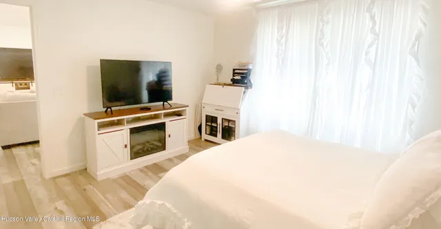 a bedroom with a bed and a flat screen tv