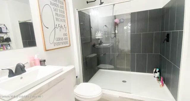 a bathroom with a sink a toilet and shower