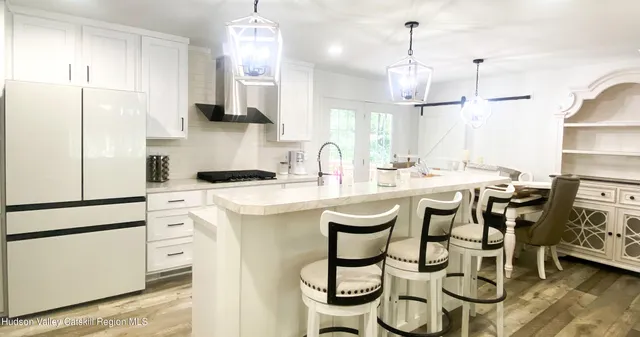 a kitchen with stainless steel appliances kitchen island granite countertop a sink a stove and a refrigerator