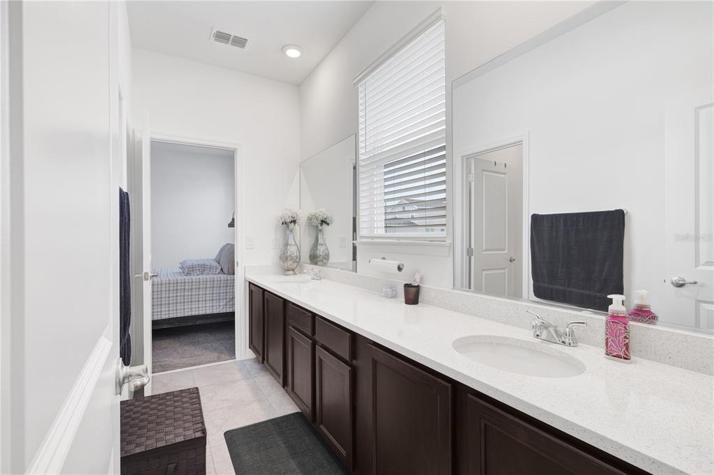 7185 Southwest 63rd Street Ocala, FL 34474 - Photo 26 of 31 a bathroom with a double vanity sink and a mirror