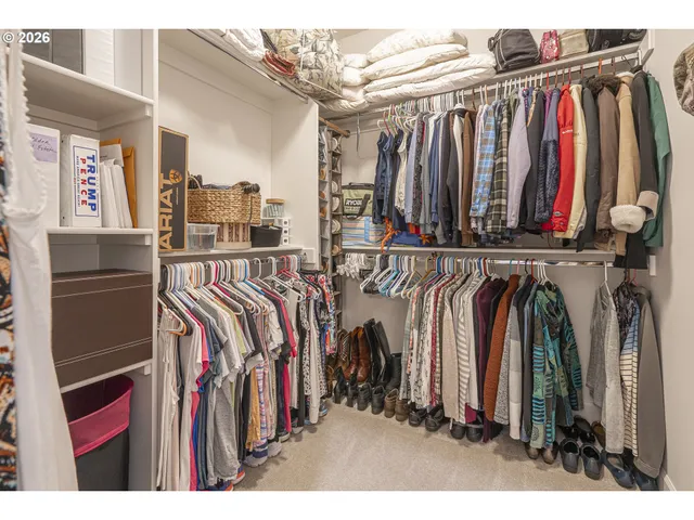 a view of walk in closet with clothes