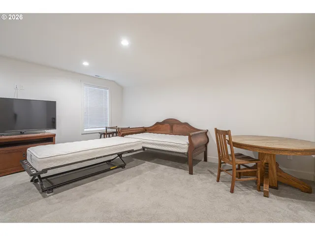 a living room with a table chair and piano