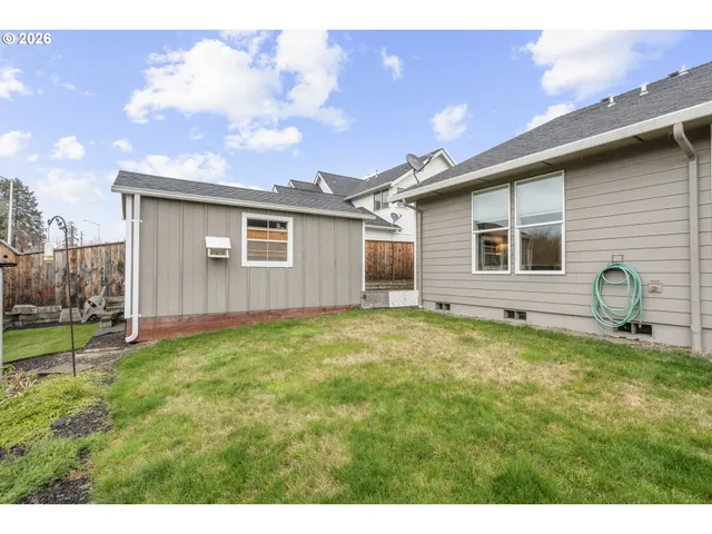 a backyard of a house with table and chairs