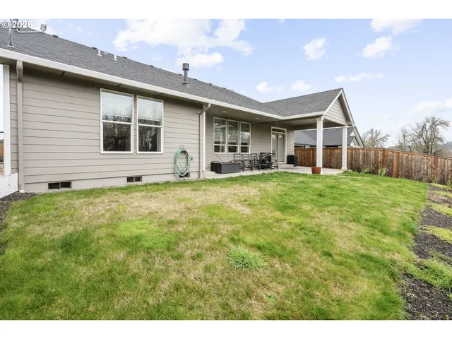 a view of a house with a big yard and large trees